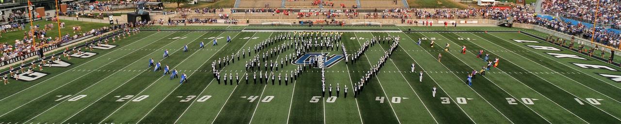 The Laker Marching Band forming the interlocking GV logo on the field of Lubbers Stadium